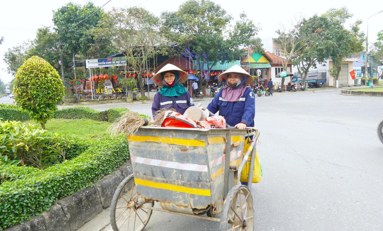 Công nhân môi trường thu gom rác tại khu vực chợ Vĩnh Điện.