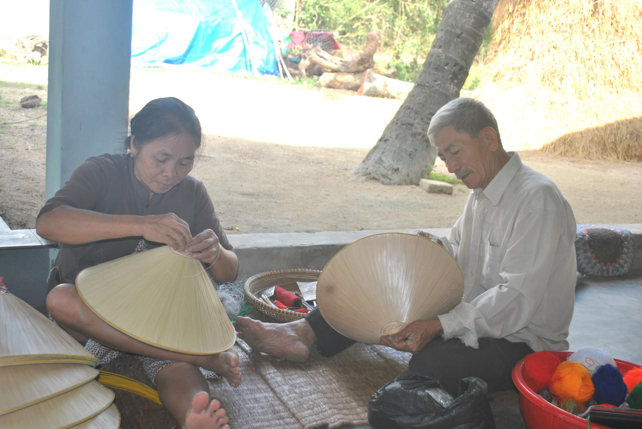 Vợ chồng nghệ nhân Đỗ Văn Lan chằm nón ngựa Phú Gia. (Ảnh: Đình Phùng)