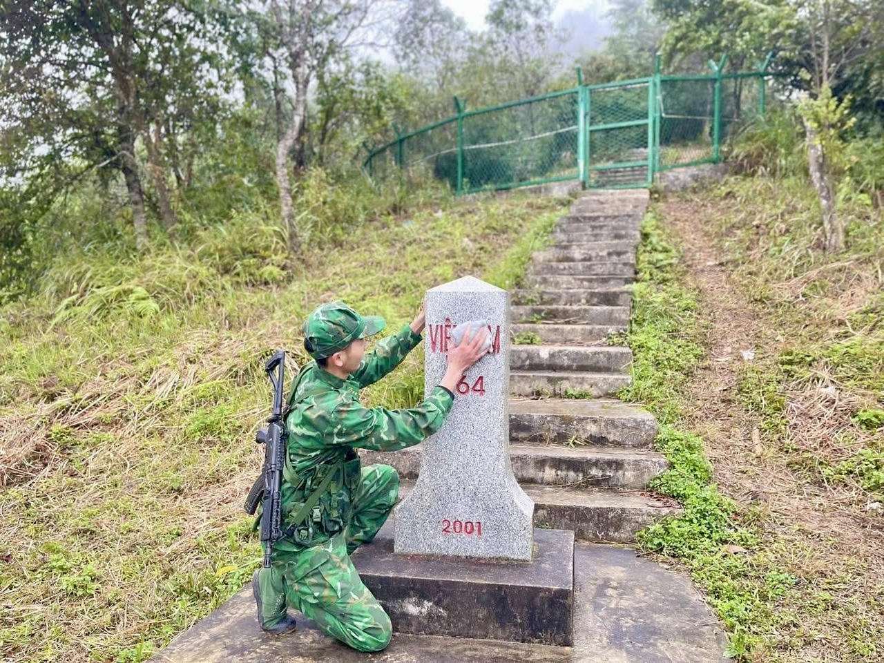 Chiến sĩ trẻ xúc động khi chạm tay vào cột mốc biên giới. (Ảnh: BP Cao Bằng)