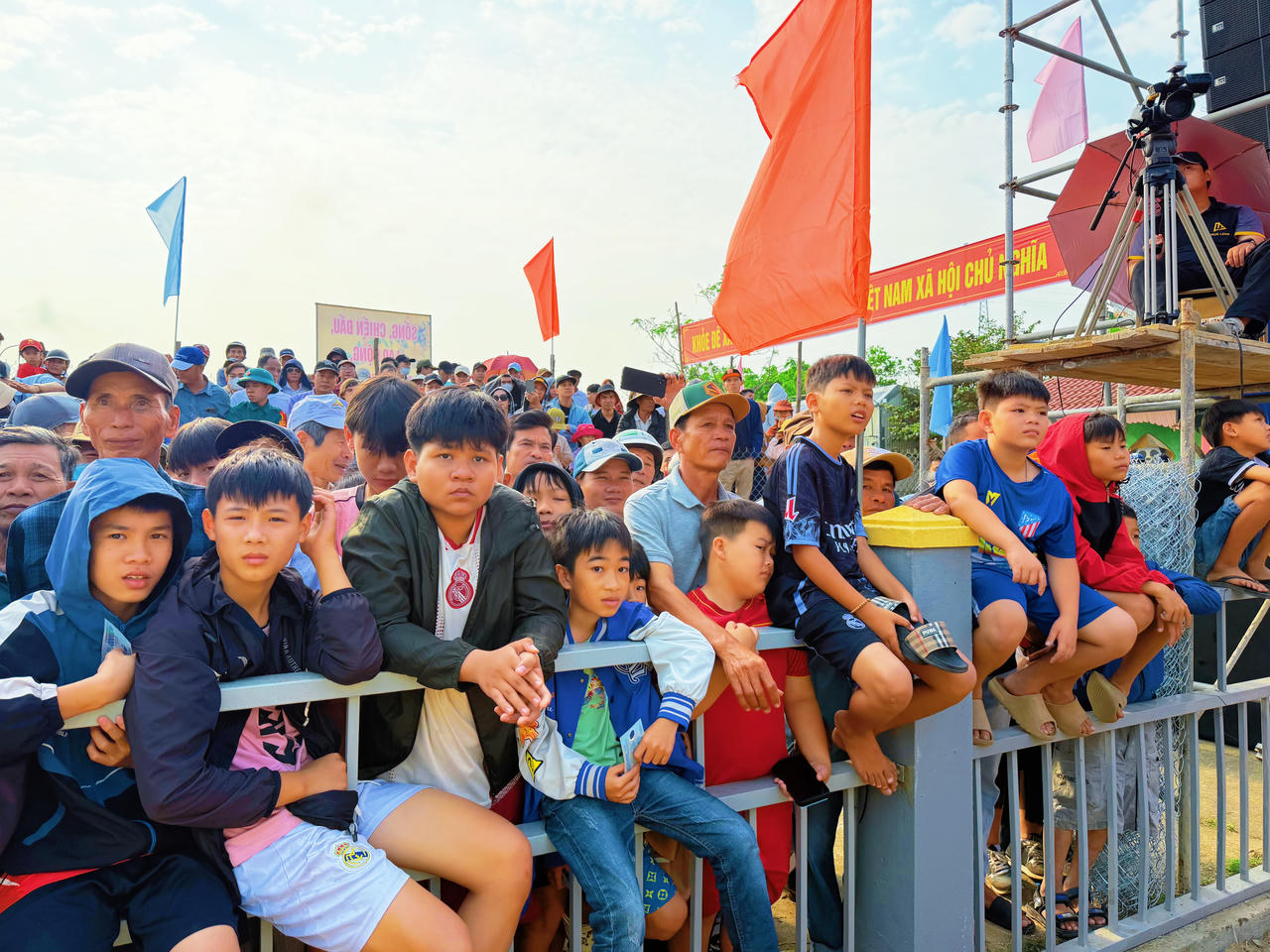 Người dân và các em nhỏ háo hức đứng kín quanh sới vật, chăm chú theo dõi những trận đấu sôi động tại Hội vật làng Sình Xuân Bính Ngọ 2026.