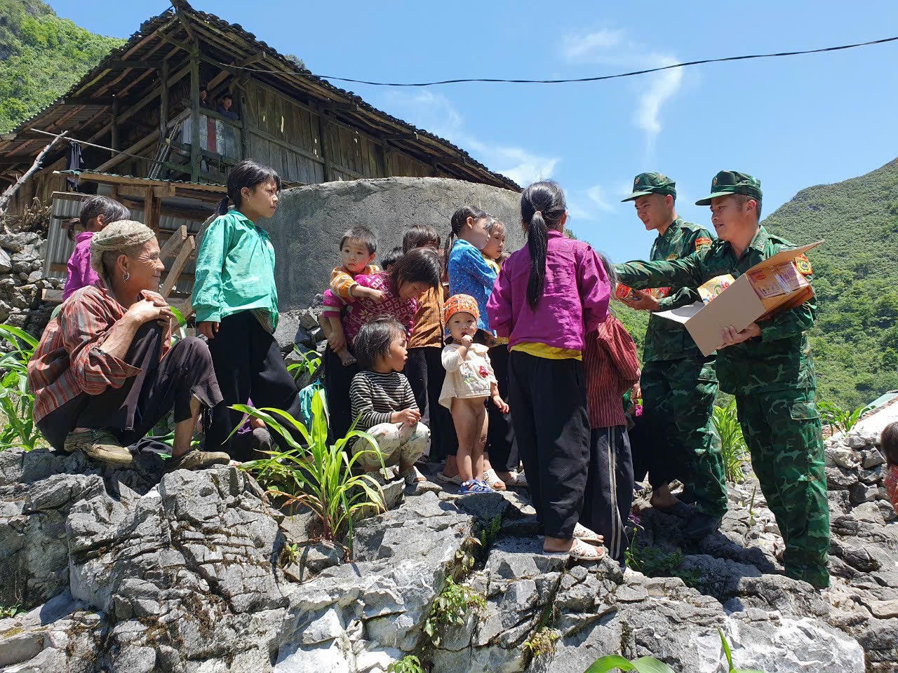 Những chiến sĩ Đồn Biên phòng Xuân Trường tặng quà cho các trẻ nhỏ. (Ảnh: Lê Hanh)