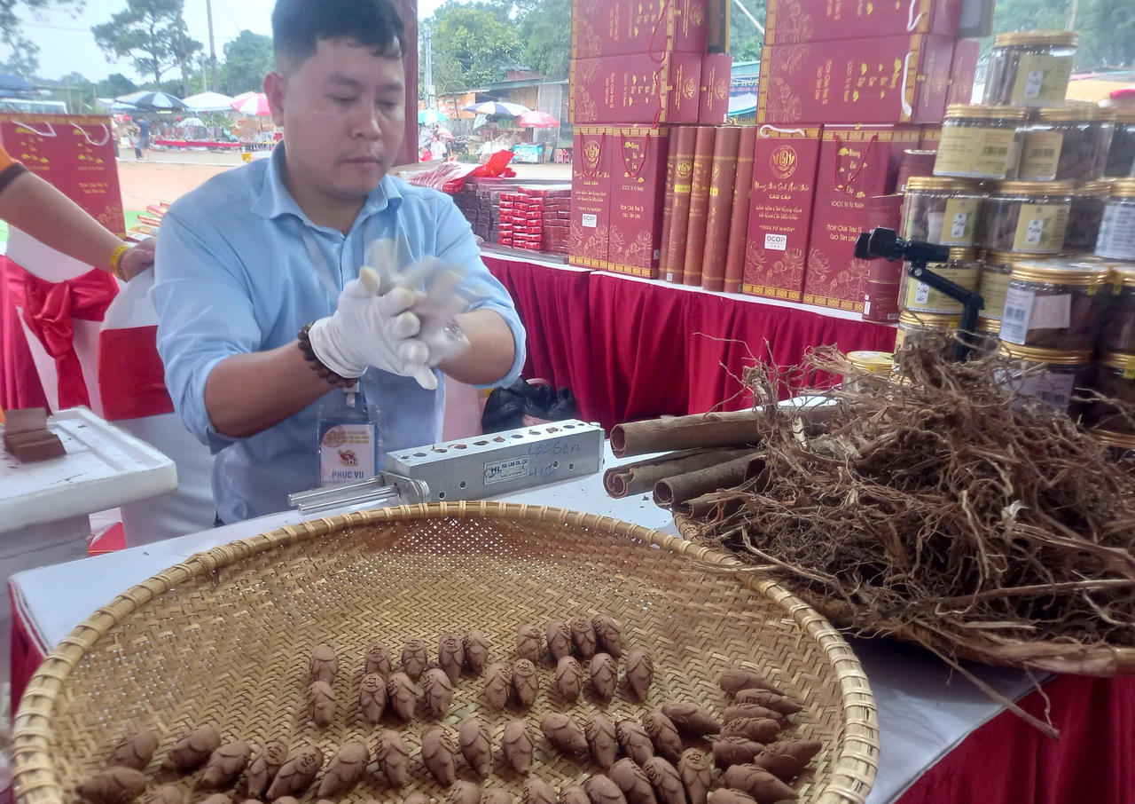 Anh Trần Đình Quốc - chủ hộ kinh doanh hương thơm Quốc Bảo đang ép nụ trầm tại gian hàng của gia đình.