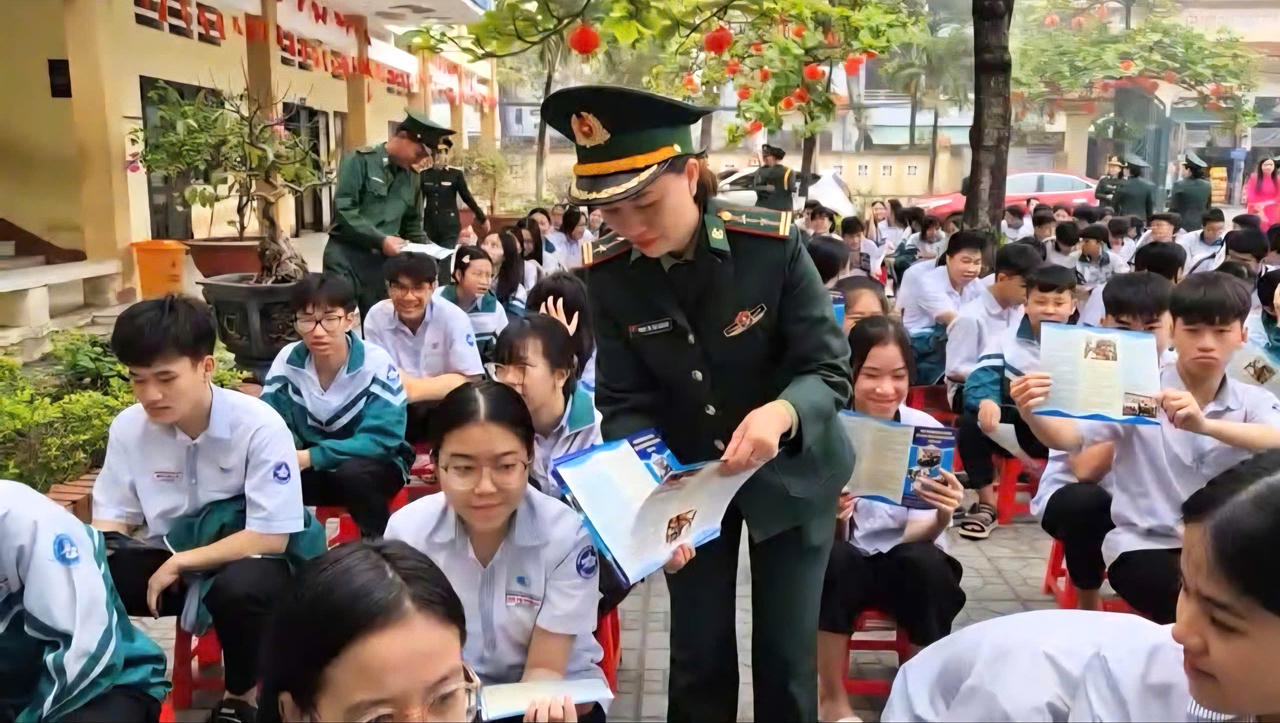 Cán bộ Bộ đội Biên phòng tỉnh Quảng Trị phát tờ rơi tuyên truyền, phổ biến kiến thức pháp luật về bảo vệ chủ quyền biên giới quốc gia cho học sinh Trường THCS Đồng Phú.