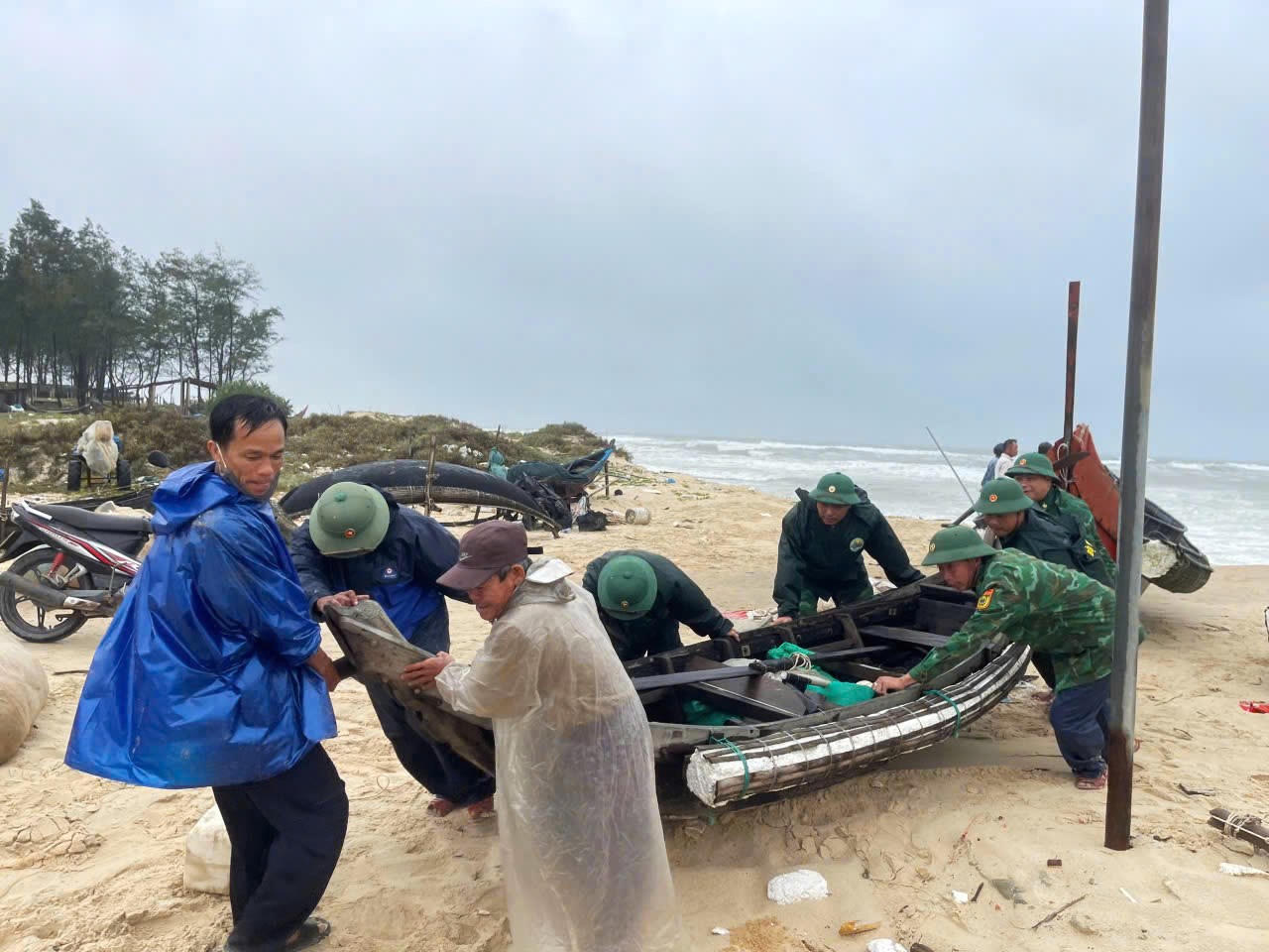 Cán bộ, chiến sĩ Bộ đội Biên phòng phối hợp với chính quyền địa phương và người dân khẩn trương di chuyển ghe thuyền, ngư lưới cụ dọc bờ biển lên vị trí an toàn.