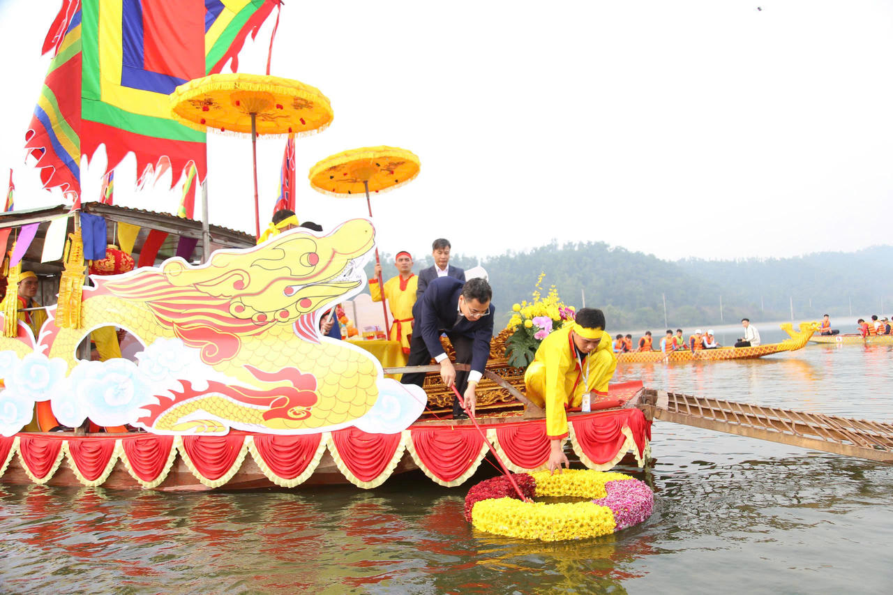 Đại biểu lấy nước trong vòng sinh khí (vòng kết bằng hoa thả xuống vùng nước trong) đổ vào bình thủy