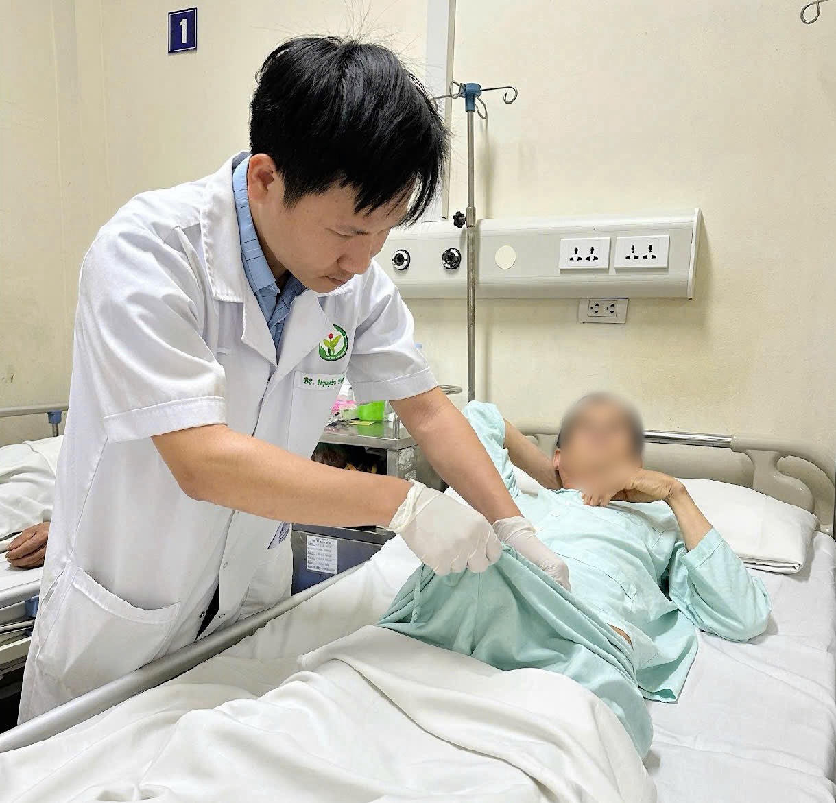 ThS.BS Nguyễn Hữu Thảo thăm khám cho người bệnh sau phẫu thuật.