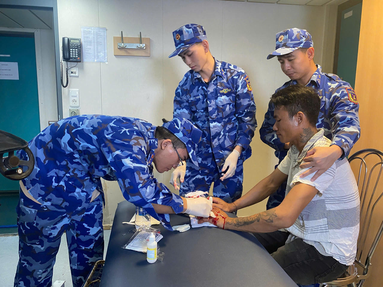 Cán bộ, chiến sĩ Tàu CSB 8005 tiến hành sơ cứu, hỗ trợ y tế cho ngư dân Vi Văn Thoải