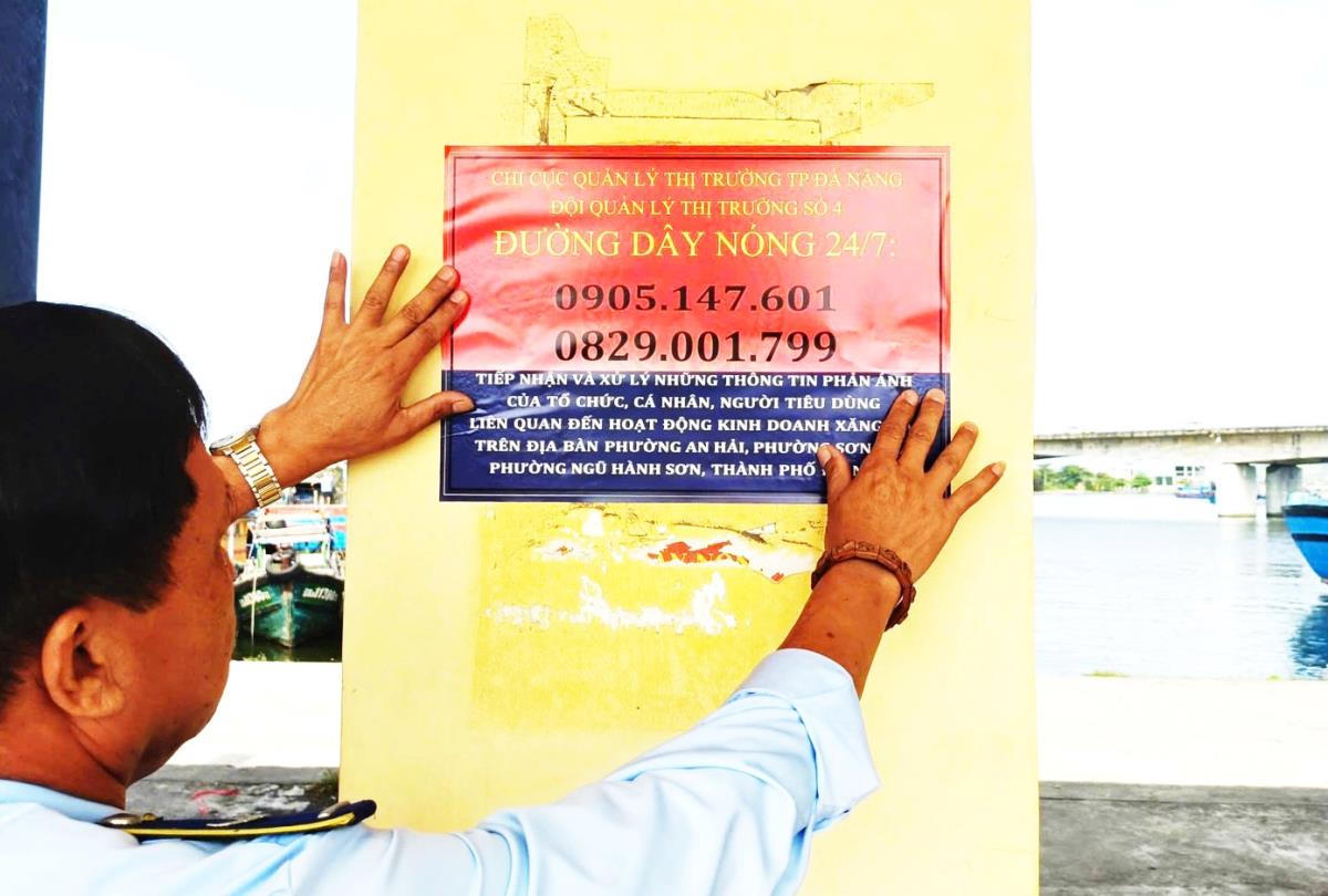 Lực lượng QLTT TP Đà Nẵng tiến hành niêm yết các "đường dây nóng" tại các cửa hàng xăng dầu trên địa bàn thành phố.