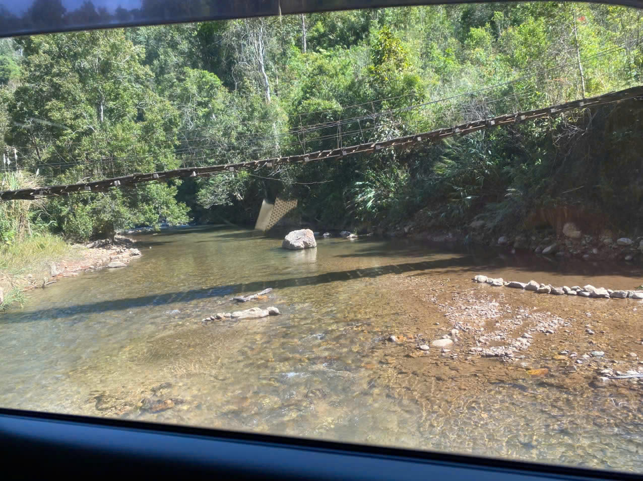 Cây cầu treo được dựng cao hơn mặt suối để người dân đi lại trong mùa mưa, khi nước dâng cao.