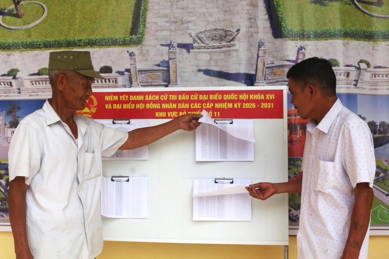Người dân xem danh sách cử tri được niêm yết tại khu vực bỏ phiếu trước ngày bầu cử.