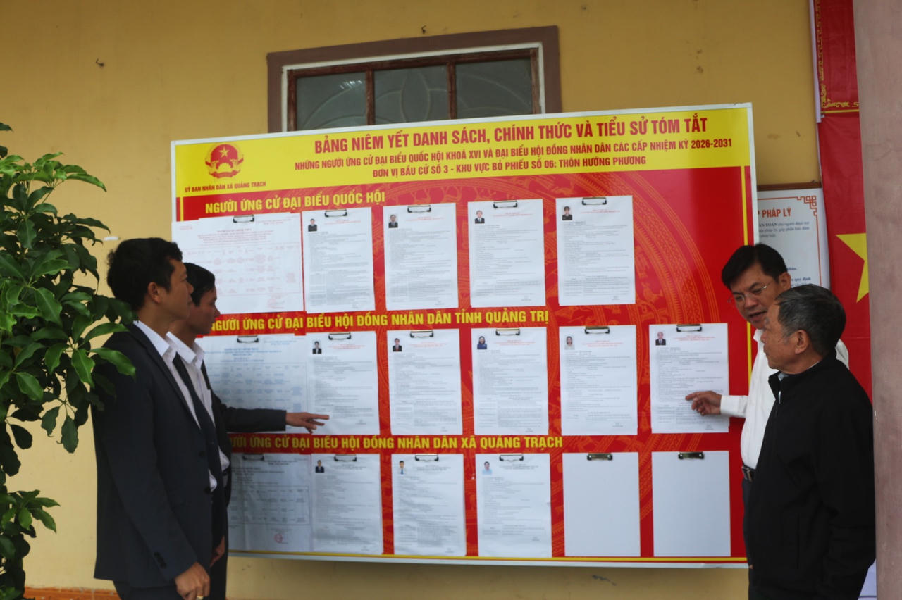 Lãnh đạo xã Quảng Trạch kiểm tra việc niêm yết danh sách người ứng cử tại khu vực bỏ phiếu.