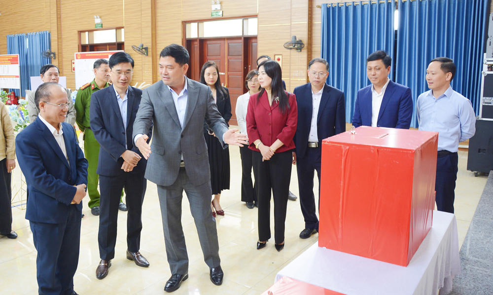 Ông Nguyễn Hồng Thái trao đổi với cán bộ làm nhiệm vụ tại khu vực bỏ phiếu Khu I, phường Võ Cường về bố trí khu vực cử tri bỏ phiếu.