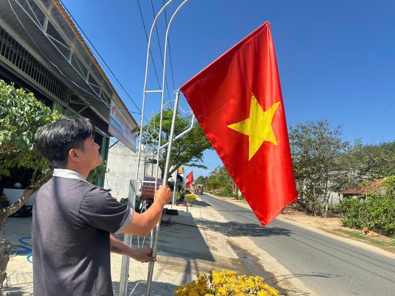 Người dân treo cờ Tổ quốc dọc các tuyến đường trên địa bàn xã Sa Loong, tạo không khí hướng về ngày bầu cử.