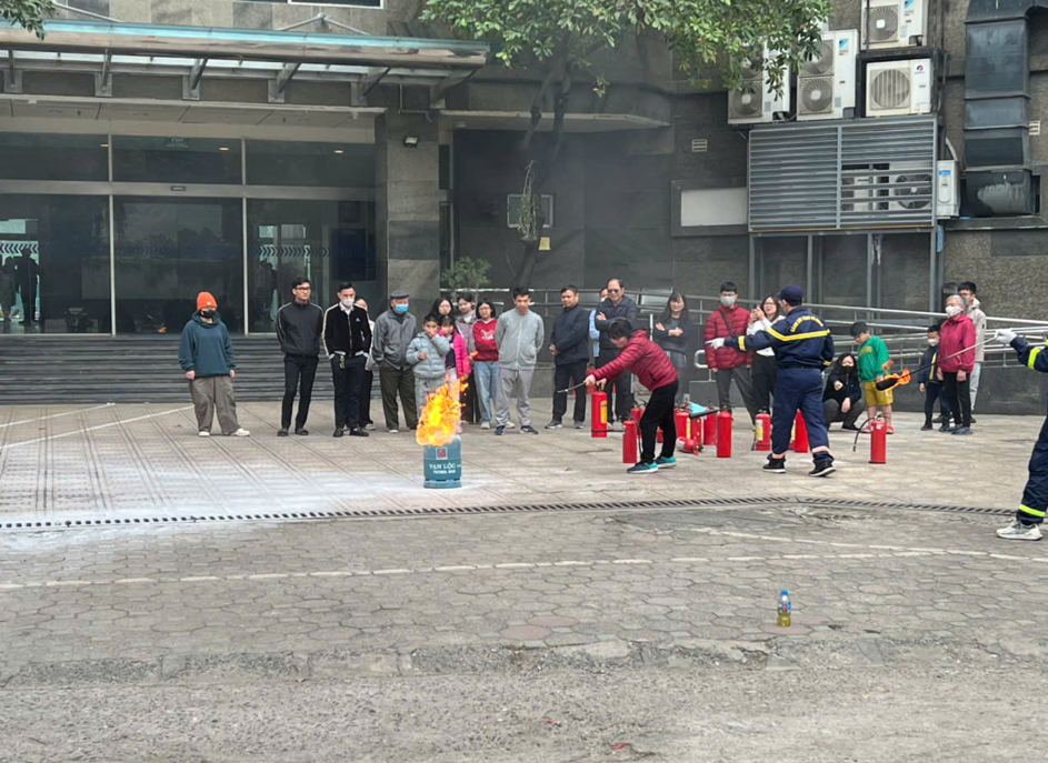 Học viên được hướng dẫn sử dụng bình chữa cháy xách tay để dập tắt đám cháy.