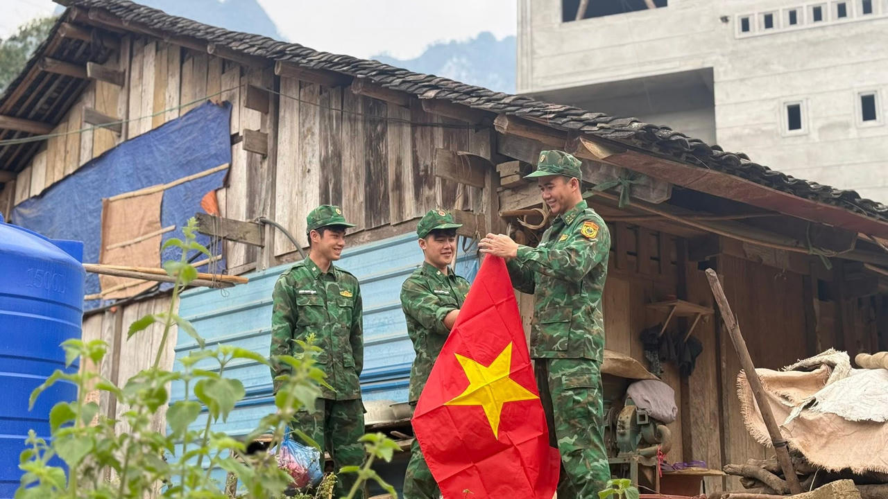 Các Chiến sĩ BĐBP Cao Bằng treo cờ Tổ quốc giúp người dân. (Ảnh: BPCB)