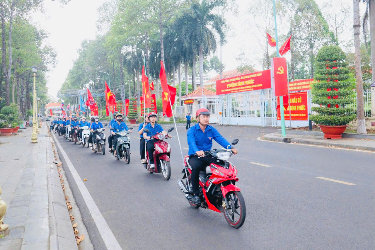 Đoàn viên, thanh niên mang cờ Tổ quốc diễu hành tuyên truyền về cuộc bầu cử.