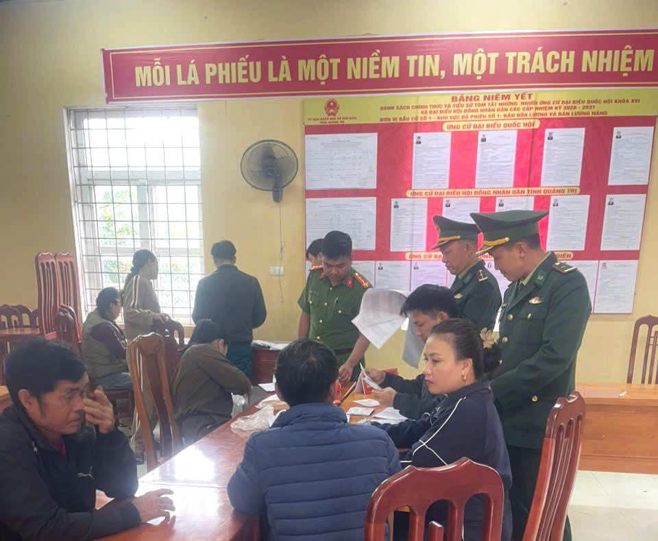 Cử tri bản Hoá Lương, xã Kim Điền tìm hiểu danh sách và tiểu sử các ứng cử viên được niêm yết tại khu vực bầu cử.