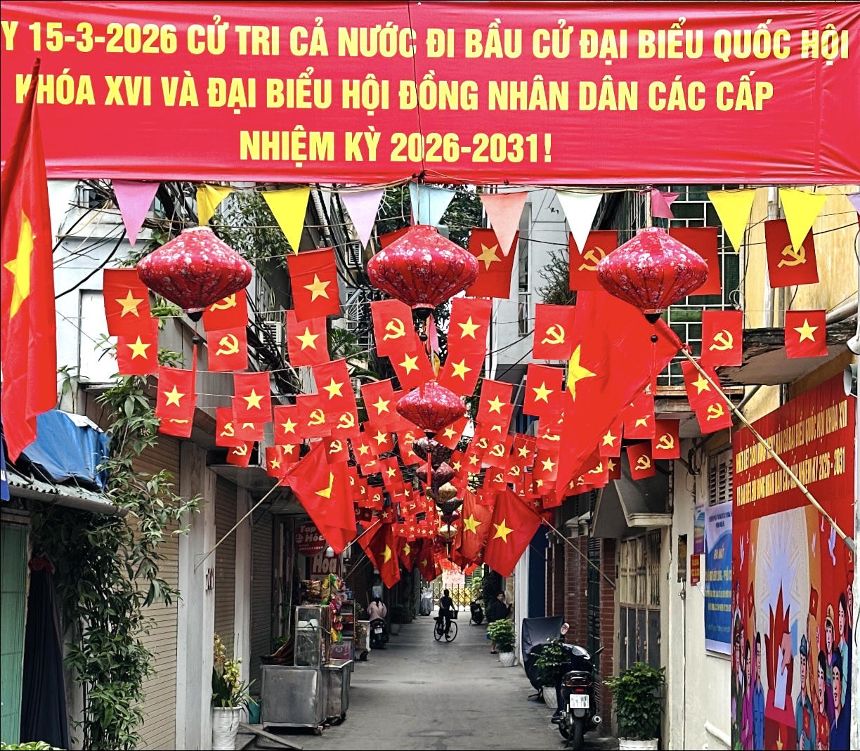 Một con ngõ tại phường Nghĩa Đô, Thành phố Hà Nội rực rỡ Cờ đỏ sao vàng và khẩu hiệu chào mừng Ngày bầu cử 15/3. Ảnh: Vân Anh