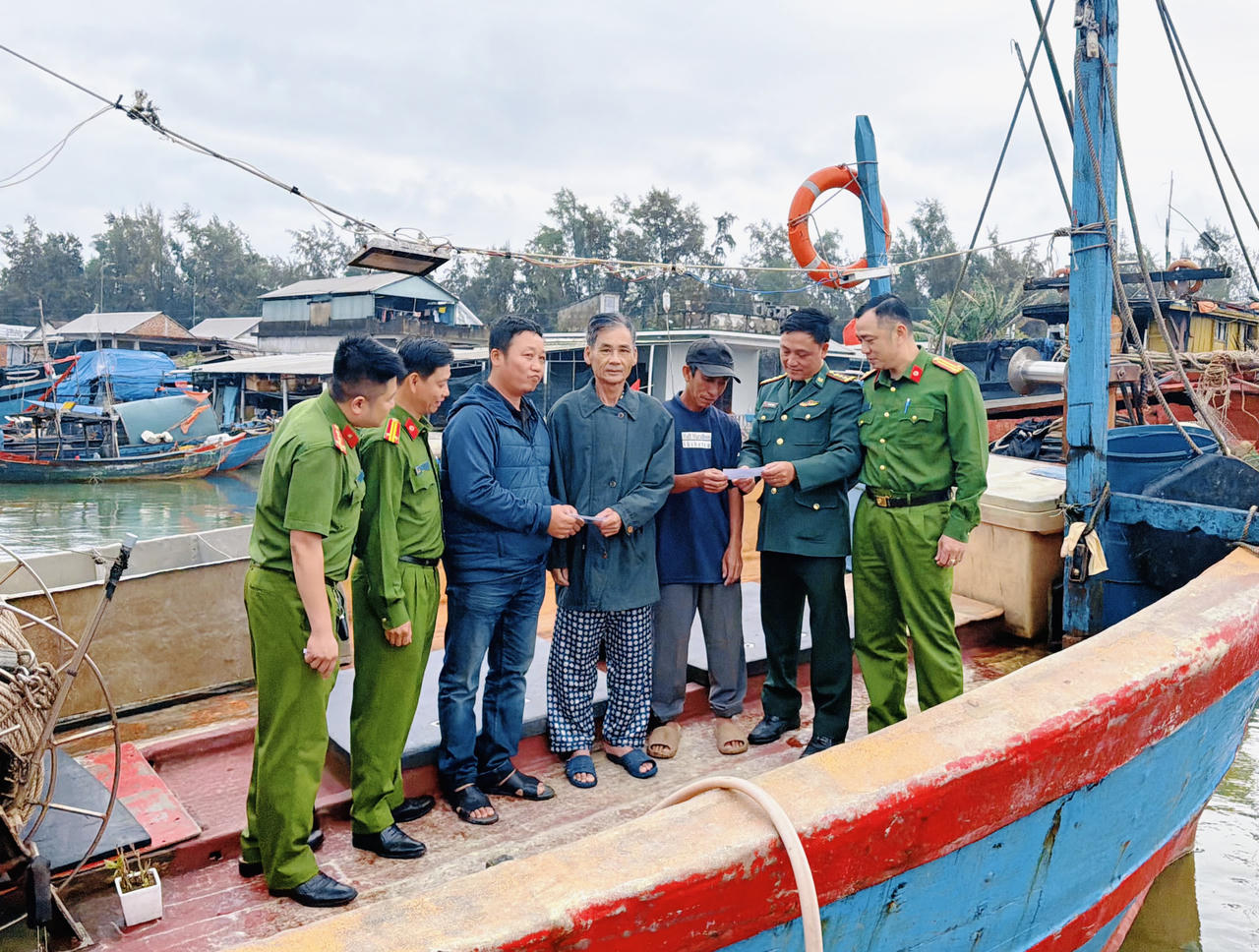 Lực lượng Công an, Biên phòng phát thẻ cử tri cho ngư dân Bùi Tuấn tại khu vực neo đậu tàu cá trước ngày bầu cử.