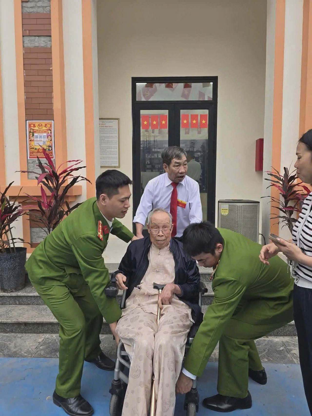 Công an phường Khương Đình hỗ trợ cử tri 92 tuổi tham gia hoạt động bỏ phiếu.