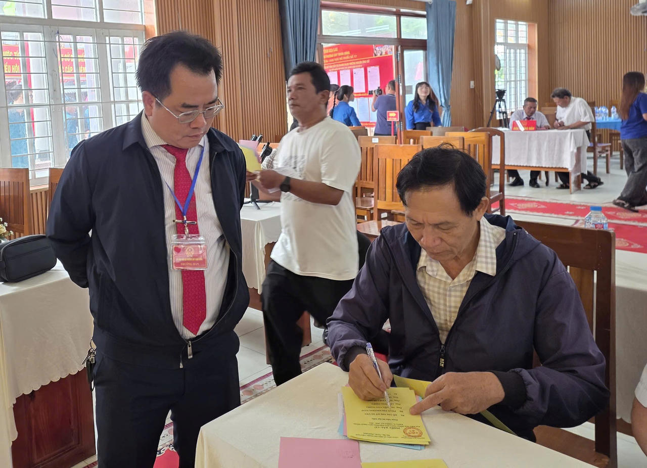 Ông Trần Việt Quang, Chủ tịch UBND phường Quy Nhơn Đông (ngoài cùng, bên trái) hướng dẫn cử tri tham gia bỏ phiếu.