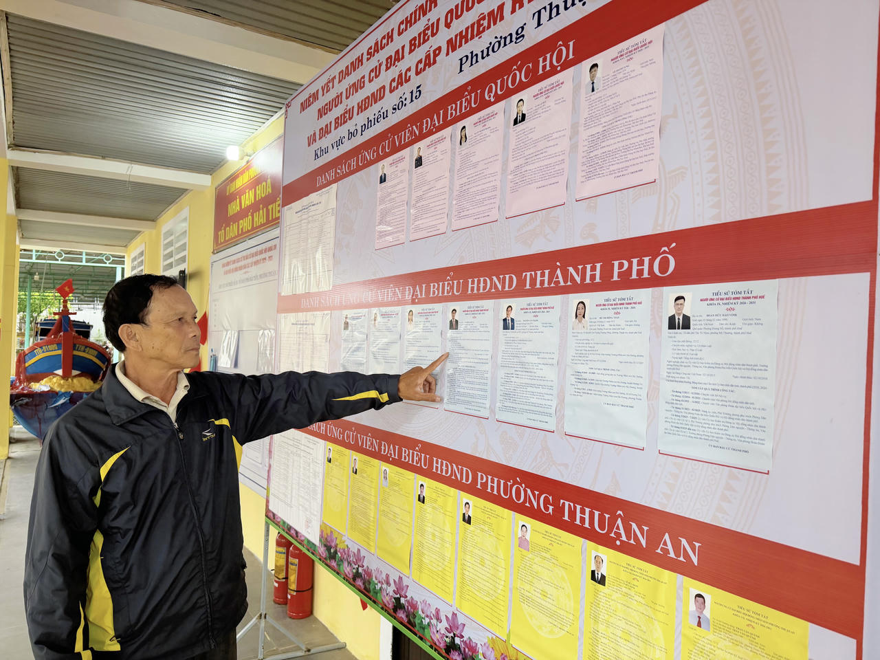 Ngư dân Trần Thanh Hữu (nguyên Tổ trưởng Tổ dân phố Hải Tiến) tìm hiểu thông tin các ứng cử viên được niêm yết tại khu vực bầu cử Tổ dân phố Hải Tiến trước ngày bầu cử.