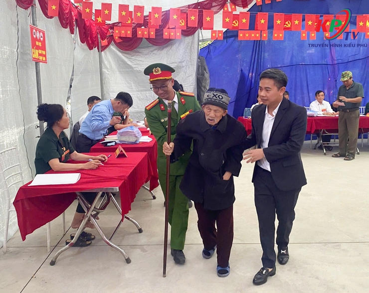 Một cử tri cao tuổi&nbsp; được ông Phùng Huy Diễn, Chủ tịch UBND xã và thành viên tổ bầu cử hỗ trợ để hoàn thành quyền và nghĩa vụ công dân&nbsp;