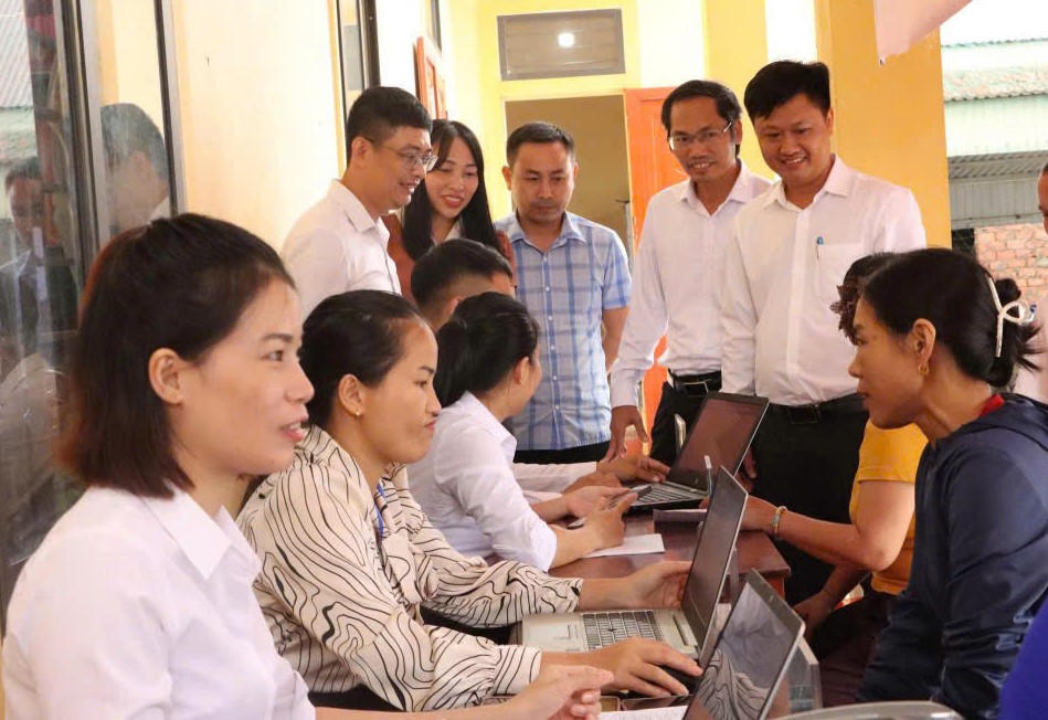 Cán bộ xã Kỳ Văn xuống tận thôn hỗ trợ người dân trong chuyển đổi số.