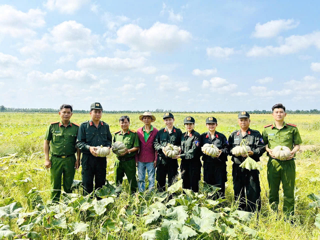 Chỉ huy và cán bộ, chiến sĩ Phòng Cảnh sát cơ động đến vườn thu mua bí đỏ tồn đọng tại hộ dân xã Đá Bạc.
