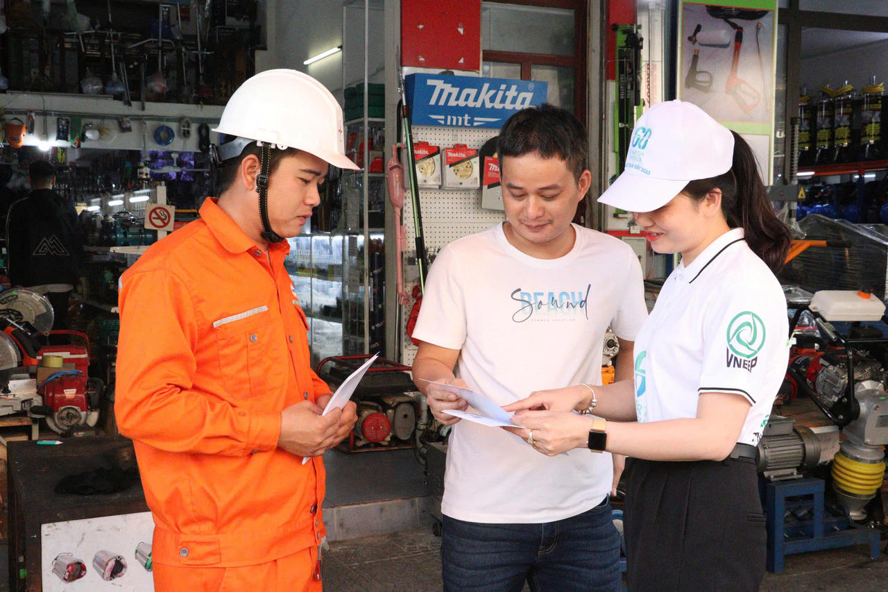 Cán bộ ngành điện tuyên truyền, hướng dẫn người dân sử dụng điện tiết kiệm, hiệu quả tại cơ sở kinh doanh.