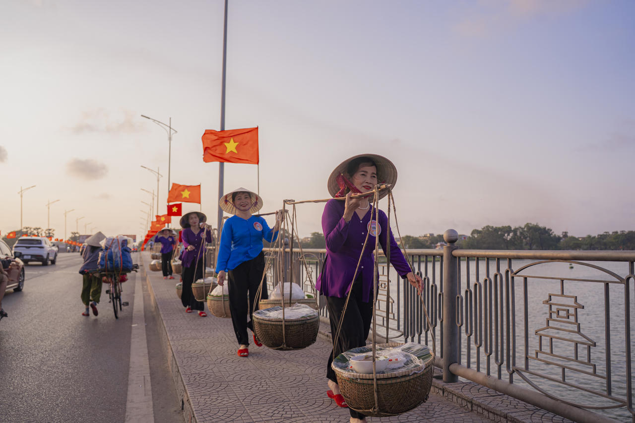 Những "O", những "Mệ" với đôi quang gánh và chiếc nón lá lặng lẽ bước qua cầu Phú Xuân, mang theo nhịp sống bình dị rất Huế