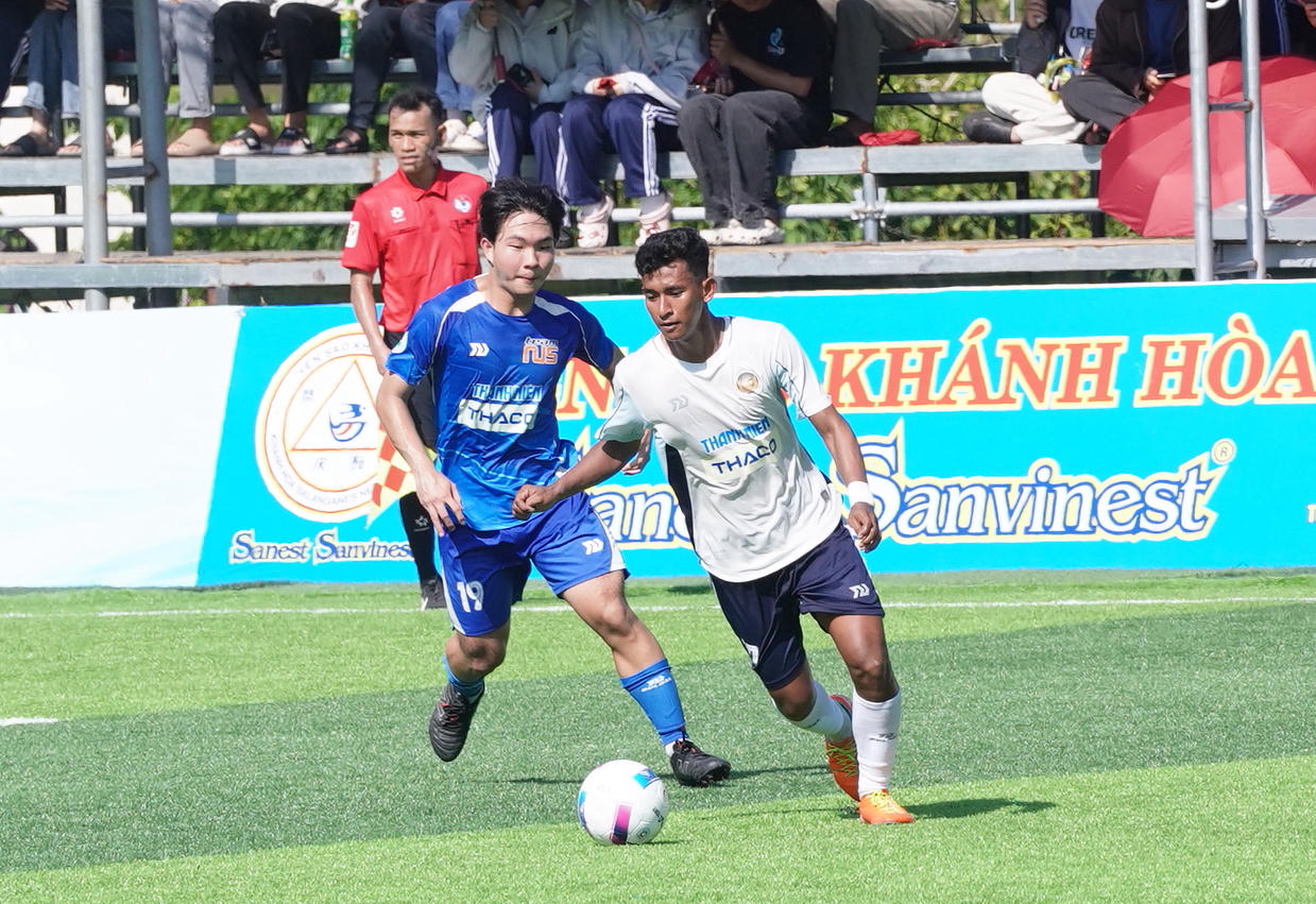 Các cầu thủ Trường Đại học Quốc gia Singapore (áo xanh) và Trường Đại học Svay Rieng (áo trắng) trong trận đấu ngày khai mạc.