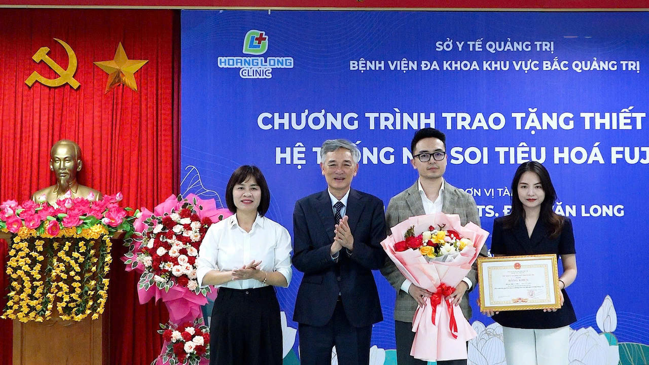 Bà Diệp Thị Minh Quyết - Giám đốc Sở Y tế tỉnh Quảng Trị trao Bằng khen của UBND tỉnh cho GS.TS. Đào Văn Long, ghi nhận những đóng góp đối với ngành y tế địa phương.