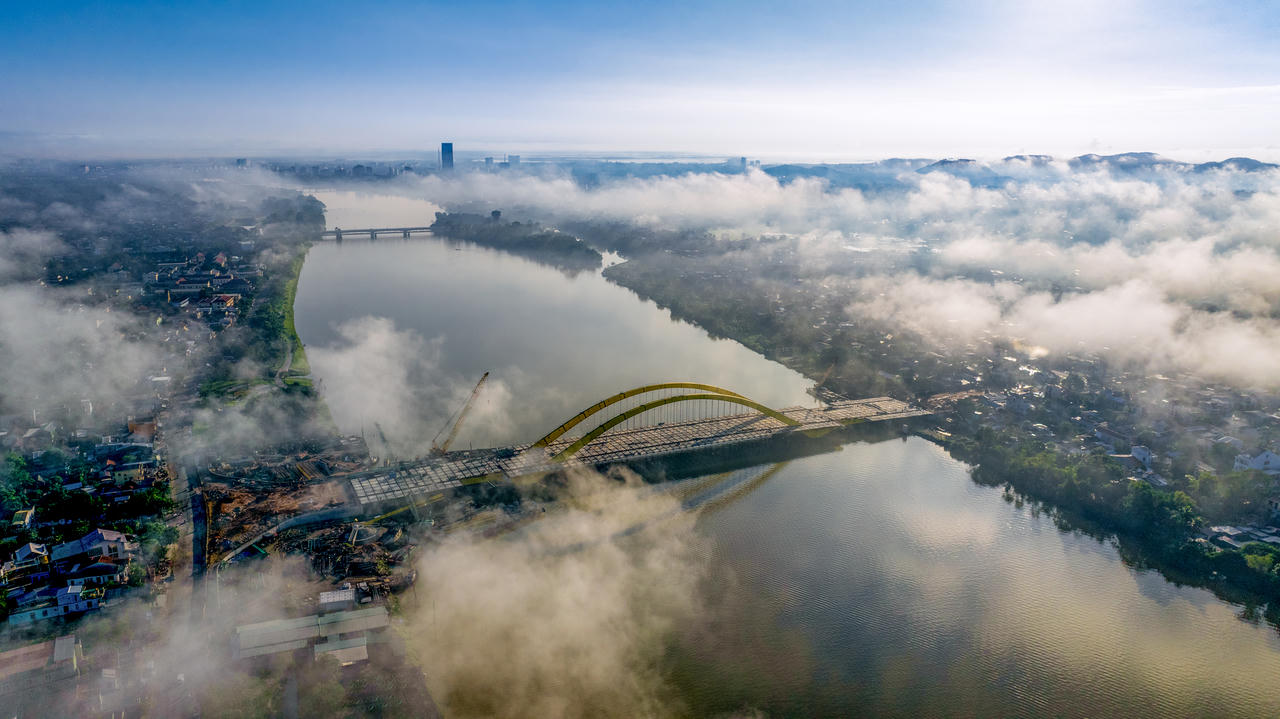 Trong màn sương sớm bảng lảng trên dòng Hương, khi cây cầu gần hoàn thiện, những nhịp vòm dần lộ hình qua tầng mây, như nét vẽ mới điểm thêm vẻ đẹp cho bức tranh xứ Thần Kinh.