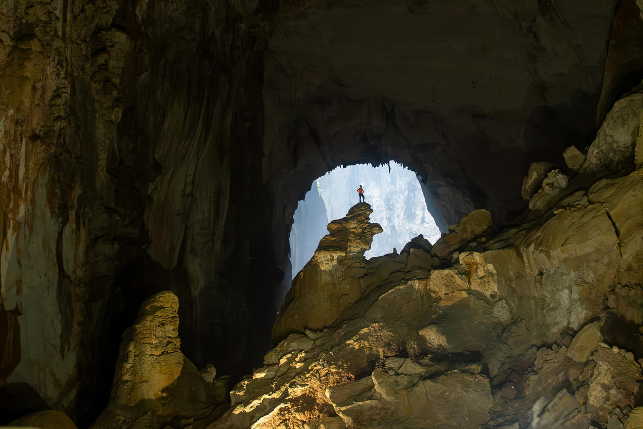 Khối thạch nhũ “Bàn Tay Chó” vươn lên giữa lòng Sơn Đoòng, nổi bật dưới ánh sáng tự nhiên xuyên qua cửa hang.