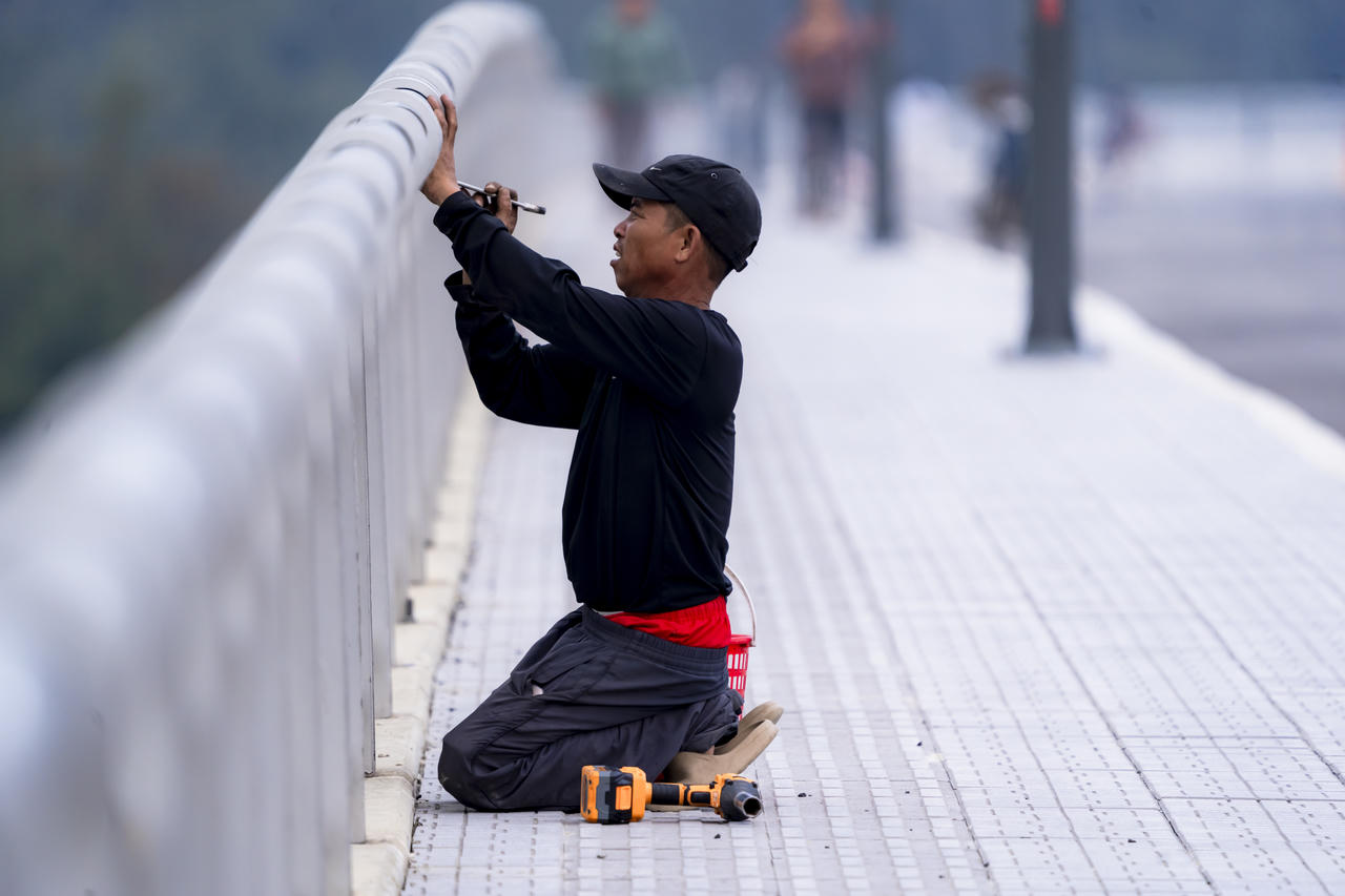 Công nhân hoàn thiện các hạng mục cuối cùng của cầu vượt cửa biển Thuận An – công trình nối làng Thai Dương Hạ và Thai Dương Thượng, dự kiến thông xe ngày 30/4.