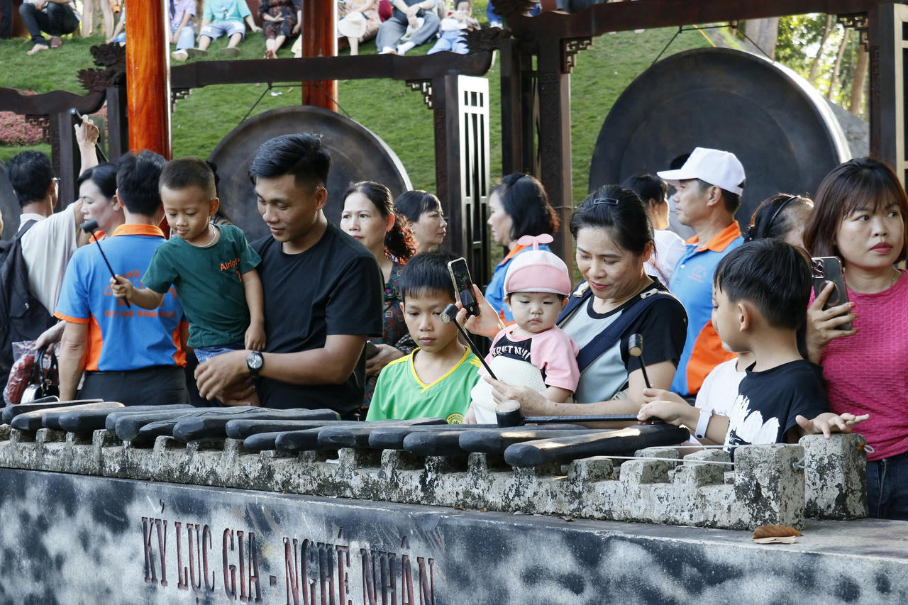 Du khách trải nghiệm chơi đàn đá tại Khu bảo tồn văn hoá dân tộc S'tiêng sóc Bom Bo.