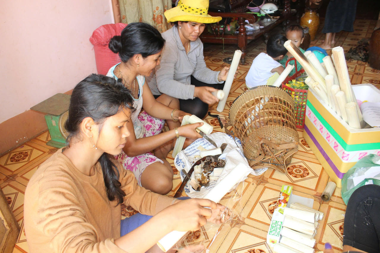 Bà con đồng bào dân tộc S'tiêng cho gạo vào ống tre để nấu cơm lam tại Khu bảo văn hoá dân tộc S'tiêng sóc Bom Bo.