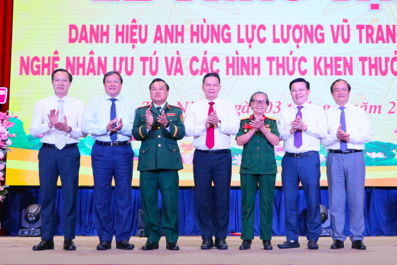 Các đại biểu chụp hình cùng “Anh hùng Lực lượng vũ trang nhân dân” Phan Thị Út.