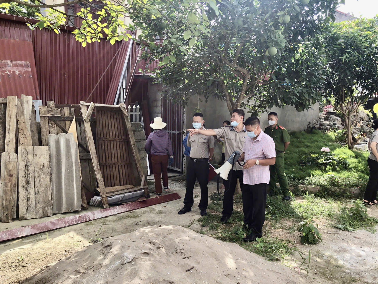Ông Hoàng Thành Minh (Đứng đầu bên trái) và các đồng nghiệp, lực lượng chức năng&nbsp;thi hành Bản án số 63/2020/DSPT của Tòa án nhân dân tỉnh Lạng Sơn. (Ảnh: Lê Hanh)