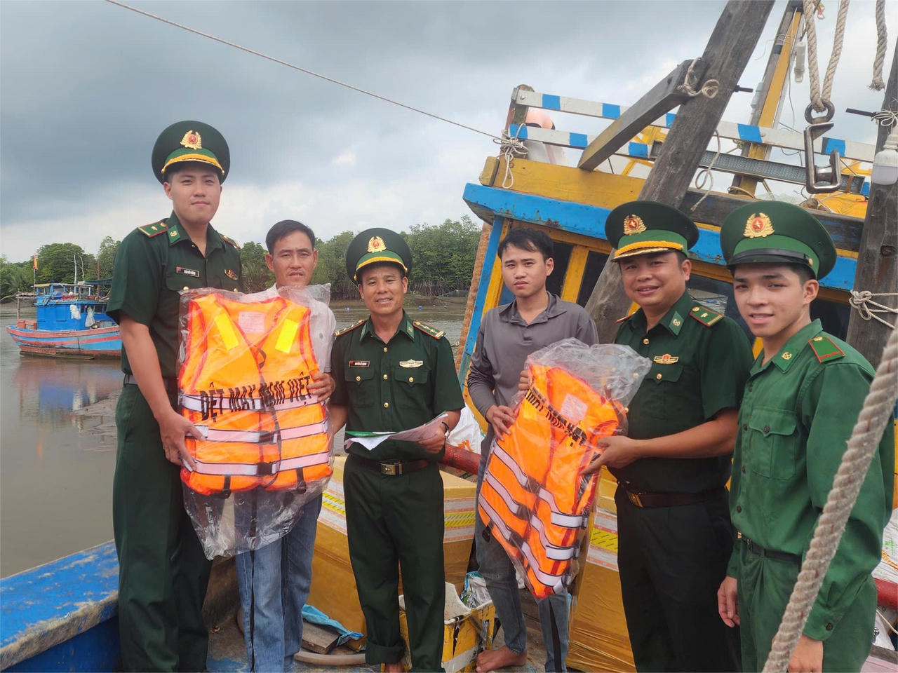 Chiến sĩ Đồn Biên phòng Phước Thuận trao áo phao cho ngư dân, lồng ghép tuyên truyền quy định về khai thác thủy sản an toàn, đúng pháp luật.