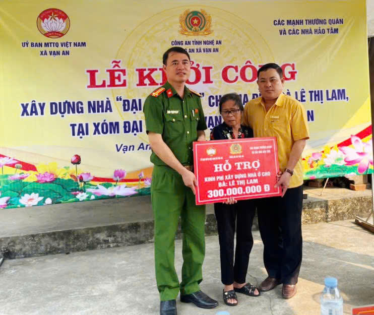 Trao tiền hỗ trợ xây nhà "Đại đoàn kết" cho bà Lê Thị Lam. (Ảnh: Hồng Sương)