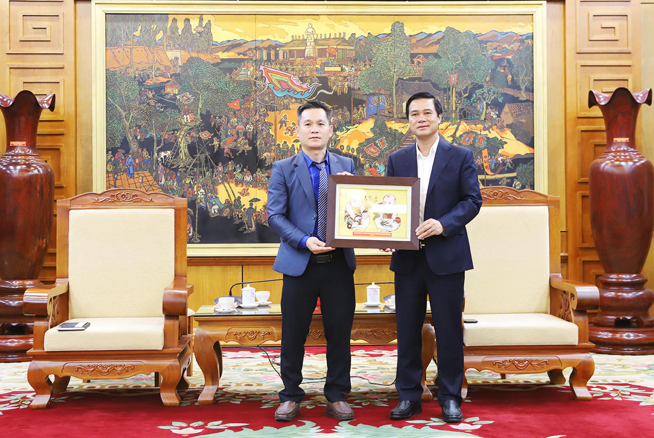Phó Chủ tịch UBND tỉnh Lê Xuân Lợi tặng tranh dân gian Đông Hồ cho đại diện lãnh đạo Sở Nông nghiệp và Môi trường tỉnh Xay Sổm Bun.