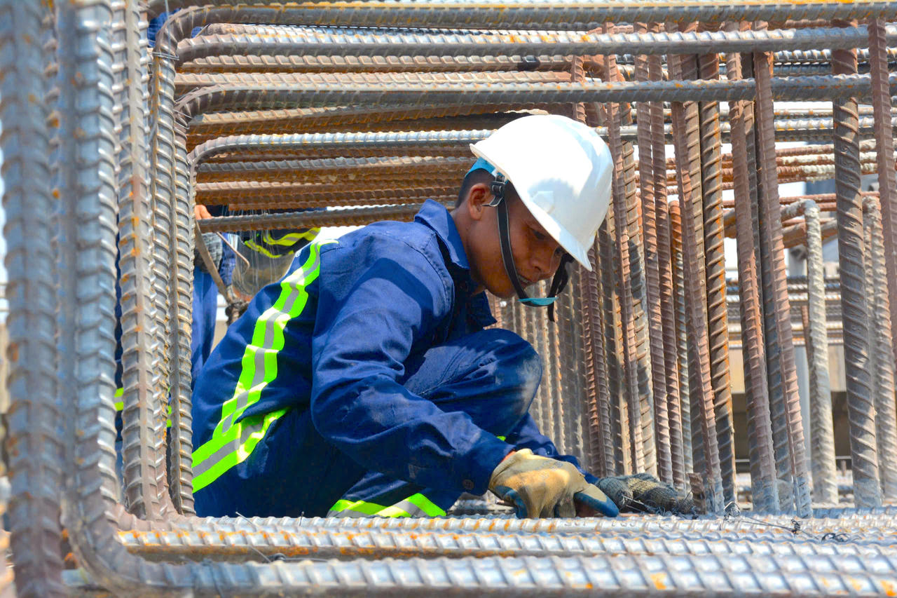 Lọt thỏm giữa "ma trận" sắt thép, người công nhân cần mẫn thắt chặt từng mối nối, trên công trường công nhân thi công 3 ca, 4 kíp đảm bảo về đích đúng tiến độ.