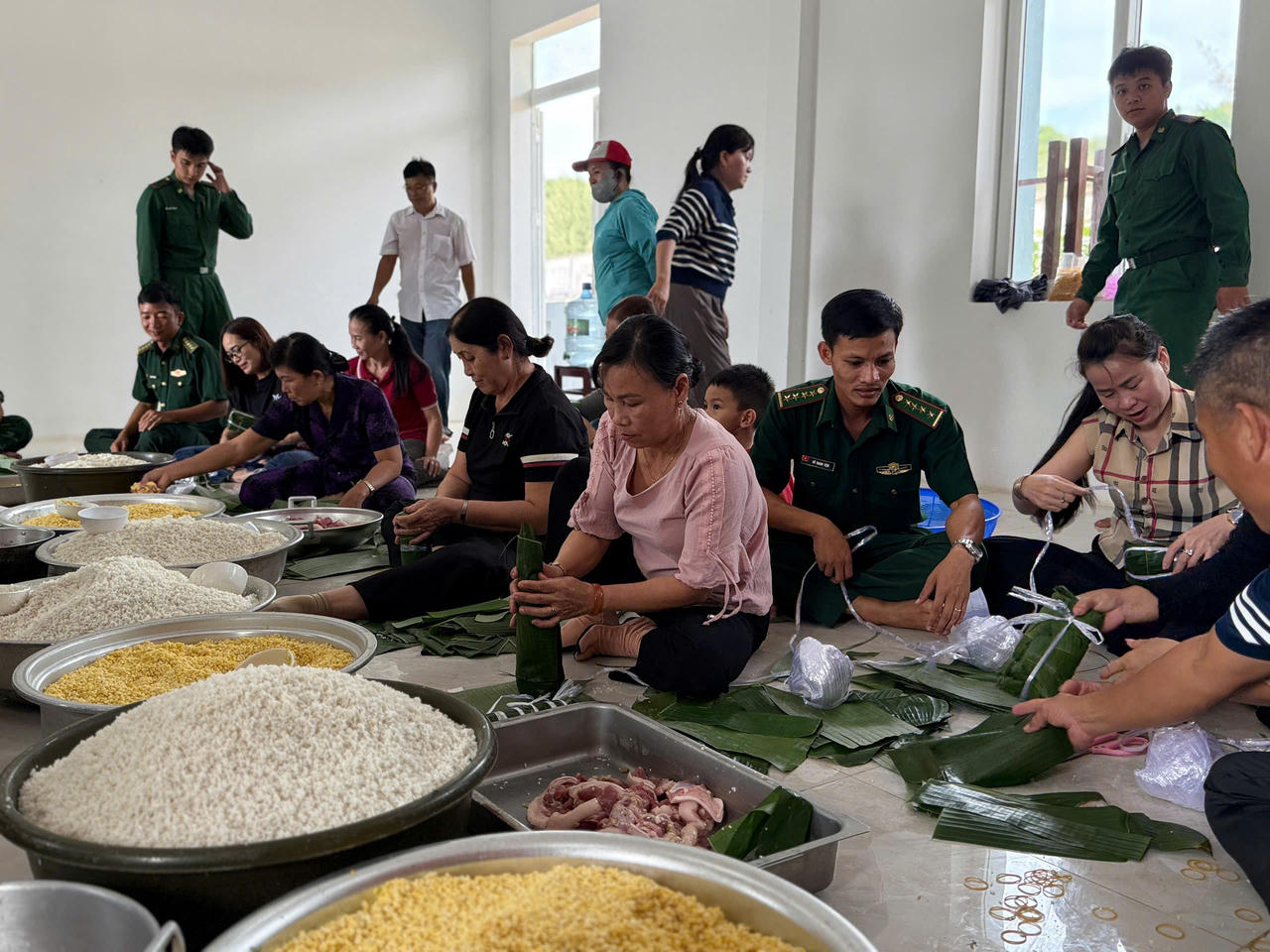 Cán bộ, chiến sĩ Đồn Biên phòng Phước Thuận phối hợp Hội Phụ nữ địa phương gói bánh gửi tặng đồng bào vùng lũ.