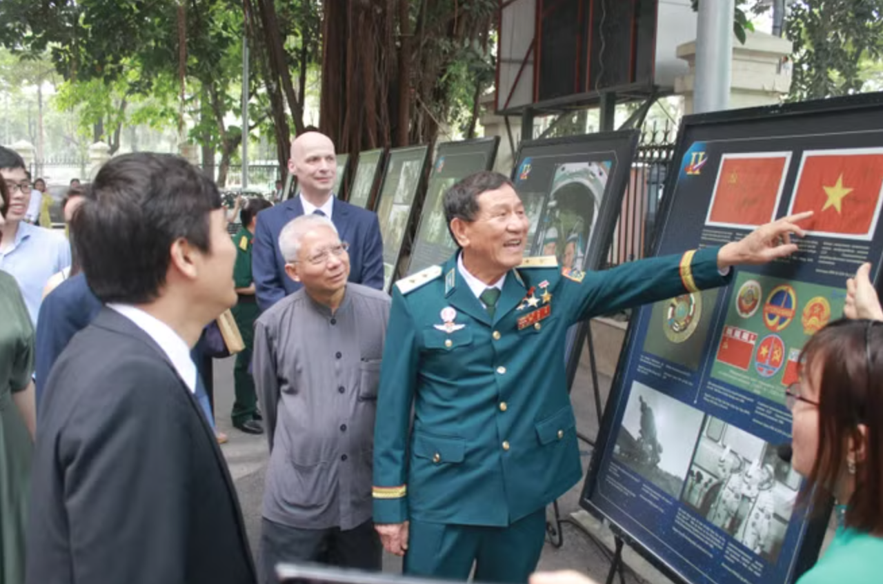 Trung tướng Phạm Tuân và hình ảnh 2 lá cờ được ký trong vũ trụ trên chuyến Soyuz-37. (Ảnh: Trịnh Việt Dũng).