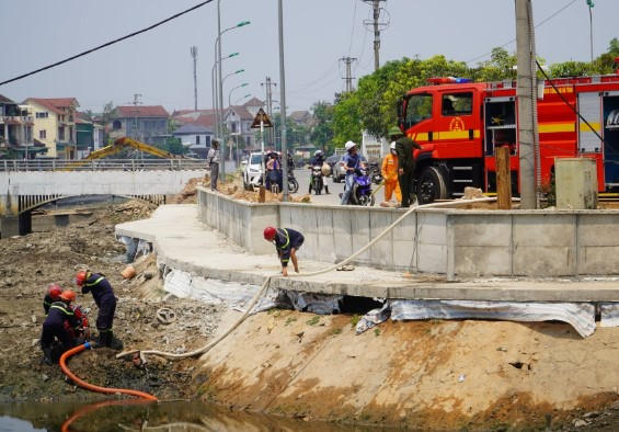Lực lượng chức năng huy động các nguồn nước sẵn có từ sông Cụt để dập lửa.