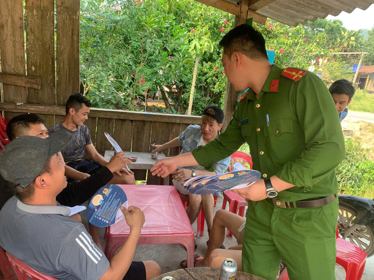 Công an xã Kim Điền trao tặng quạt tay tuyên truyền pháp luật cho người dân trên địa bàn.