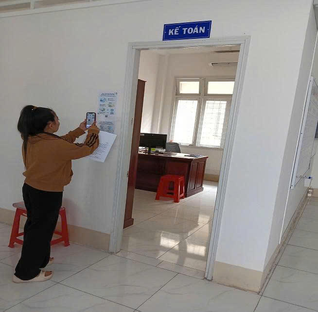 Người dân thực hiện quét mã QR code nộp tiền thi hành án, sáng kiến của Phòng THADS khu vực 2 - Đồng Tháp. (Ảnh: Văn Thành)