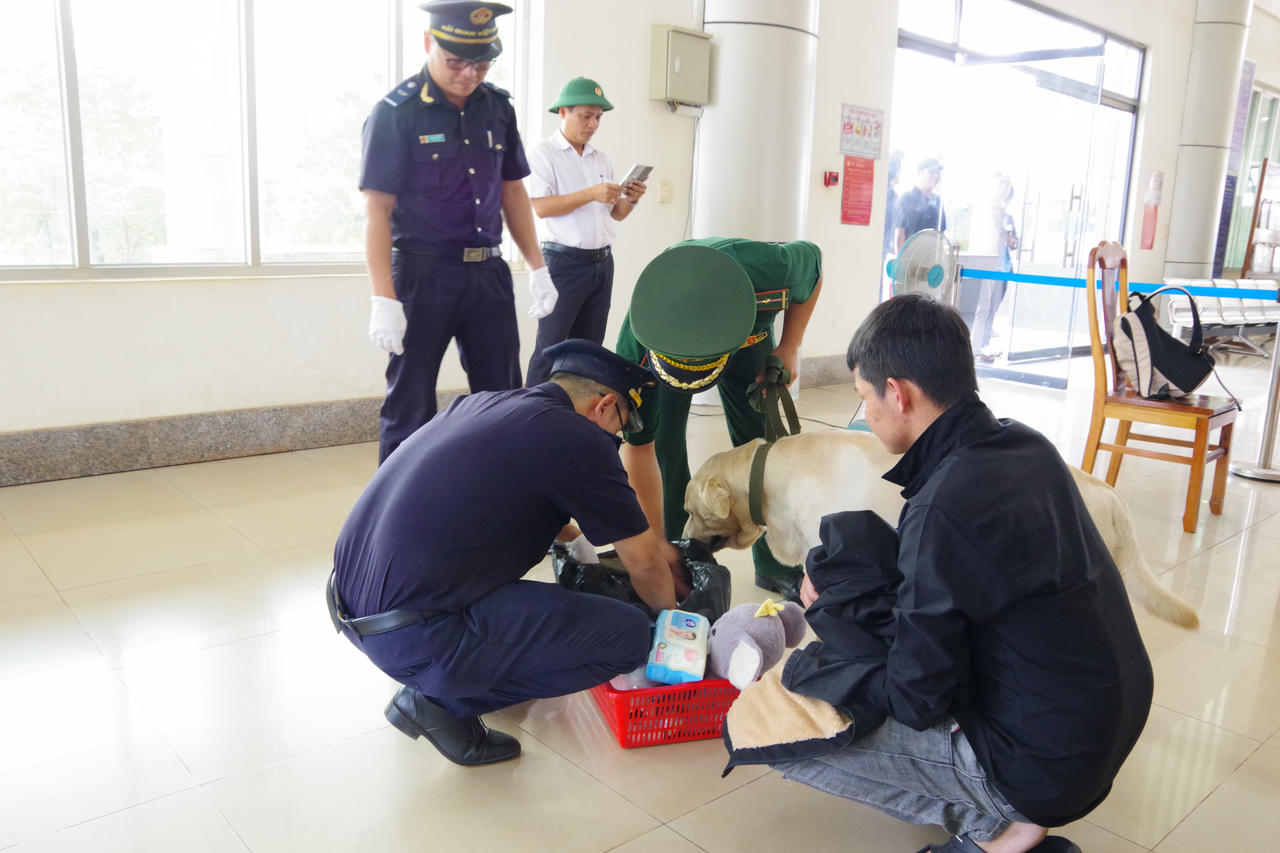 Lực lượng chức năng kiểm tra hành lý của các công dân Việt Nam được lực lượng chức năng Campuchia trao trả qua cửa khẩu quốc tế Mộc Bài. Ảnh: Lê Đồng